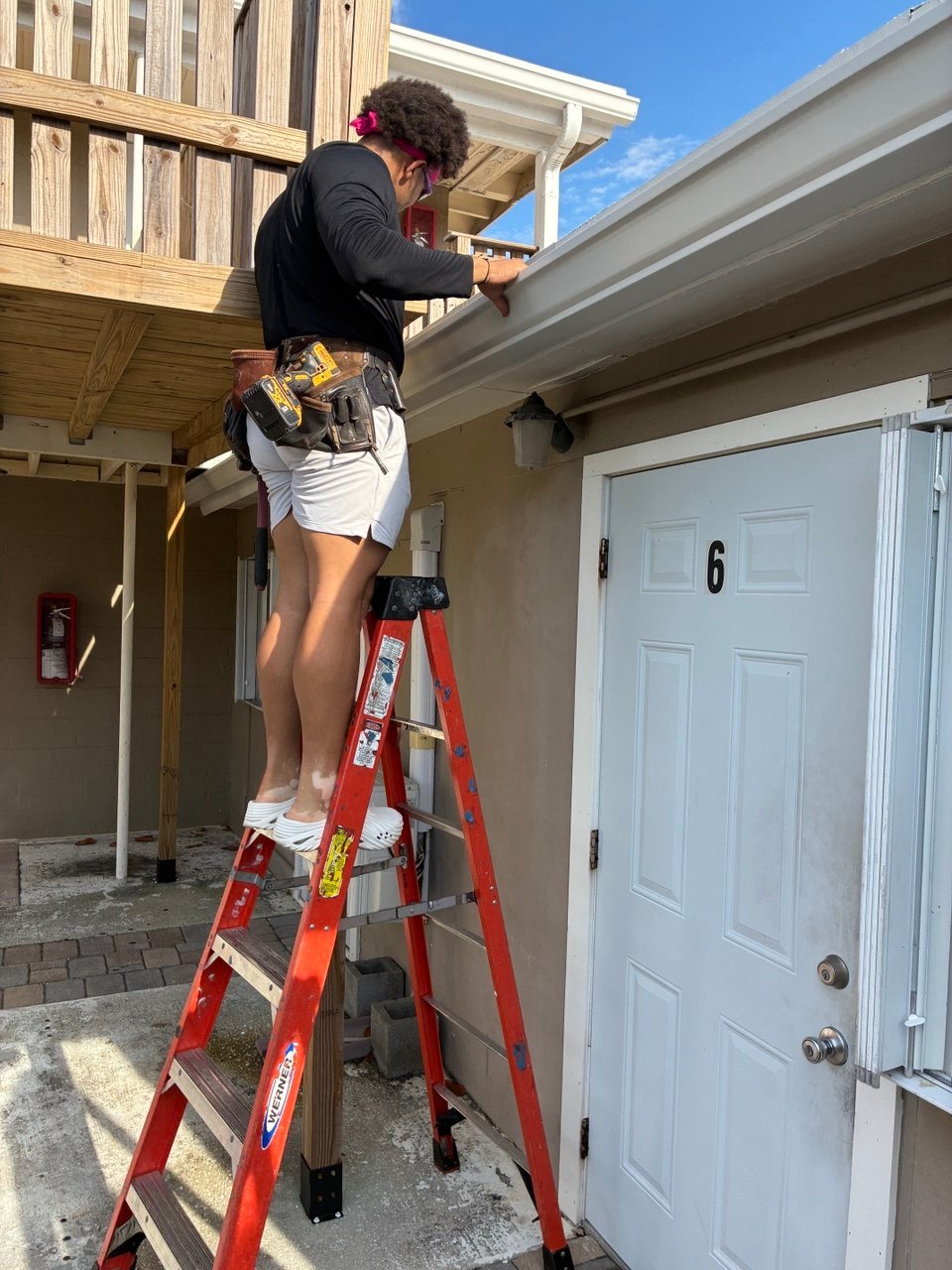 Palm Beach Gutter technician installing gutter from a ladder